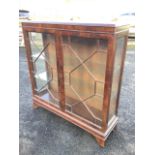 A mahogany china cabinet with moulded top above astragal glazed doors enclosing glass shelves with