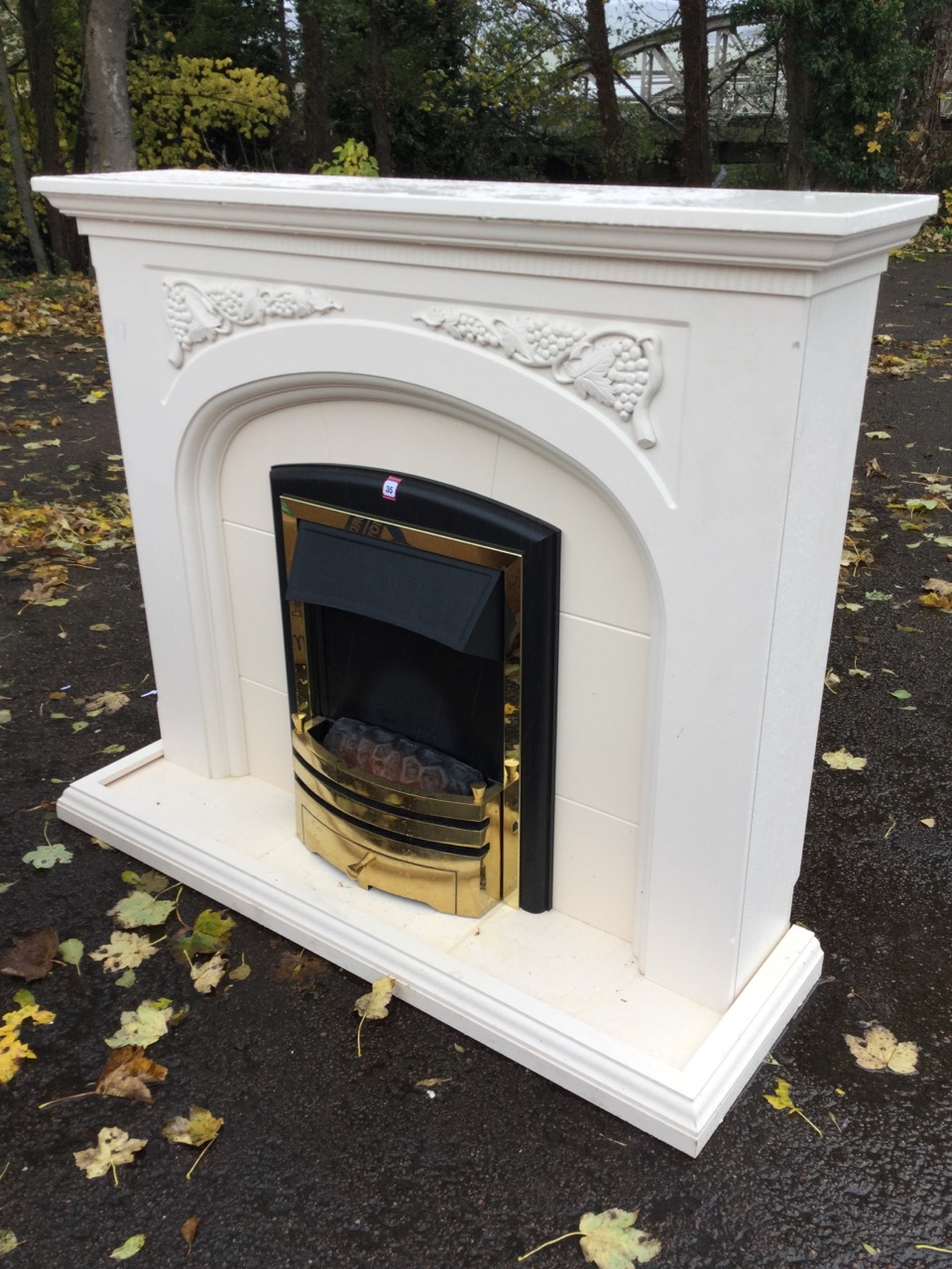 A contemporary painted chimneypiece, the mantelpiece with dentil cornice above vine moulded