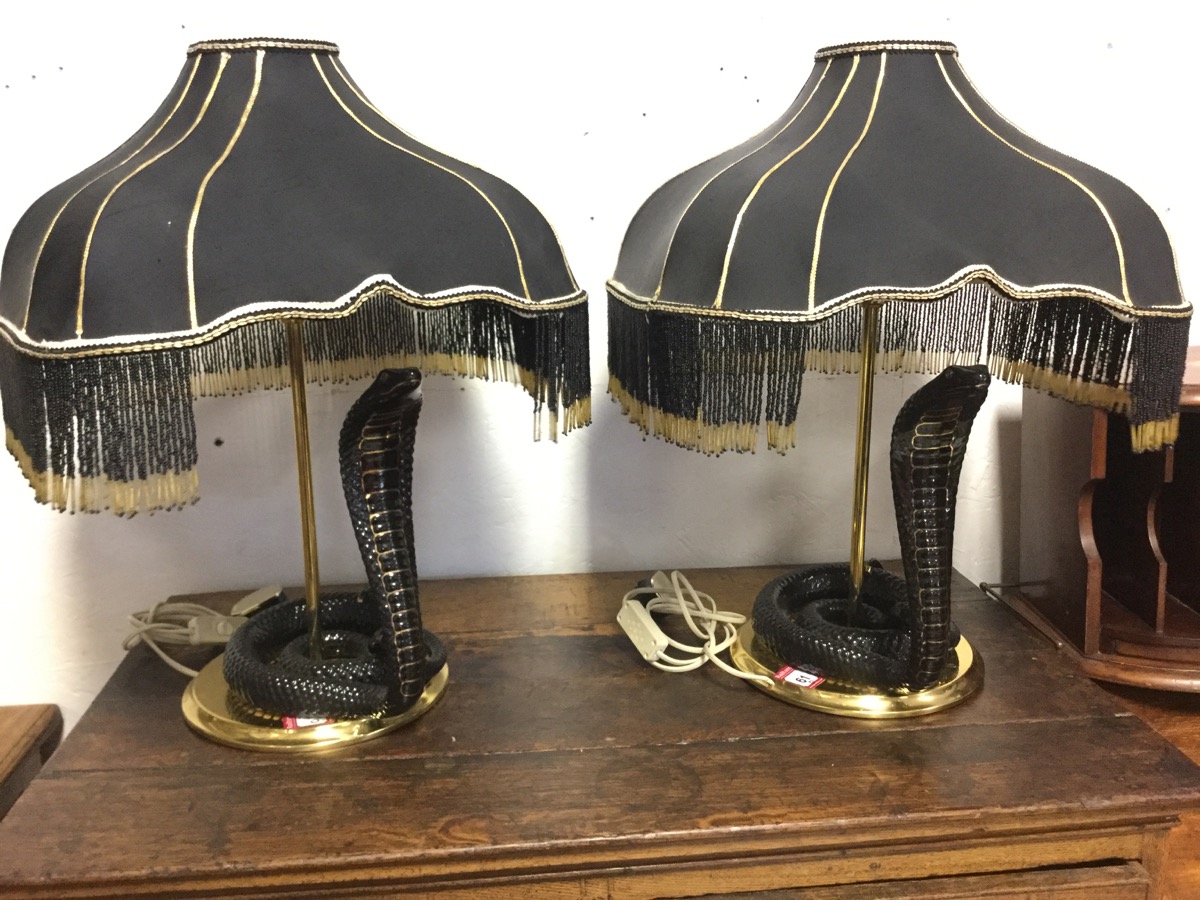 A pair of brass tablelamps with square black beaded shades above black & gilt glazed porcelain