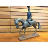 A stylised carved oak horse with European soldier up, raised on rectangular plinth - signed