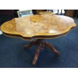 A walnut scalloped top dining table, the tip top on bulbous turned column with quadripartite
