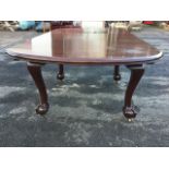 A mahogany dining table with spare leaf, the rectangular moulded top with rounded ends on bulbous