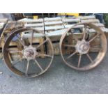 A pair of nineteenth century cast iron agricultural wheels with wide rims, and rod spokes around