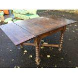 An oak draw-leaf dining table, the panelled top on barleytwist legs joined by rectangular crossed