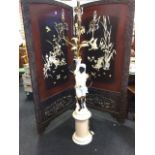 A European porcelain blackamoor standard lamp with four candlelights on gilt leaf branches hung with