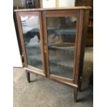 A glazed cupboard with fluted moulded glazed doors enclosing shelves, raised on later tapering legs.