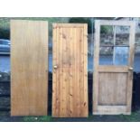 A glazed pine door with tongue & grooved panel to base; a plain tongue & grooved panelled door;