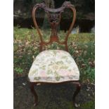 A late Victorian mahogany saloon chair, the foliate scrolled leaf carved back above a pierced splat,
