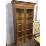 A glazed pine cupboard with moulded cornice above two doors. (40.5in x 13.5in x 75in)