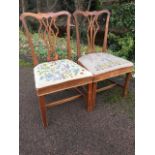 A pair of chippendale style mahogany dining chairs with shaped back rails above pierced splats,