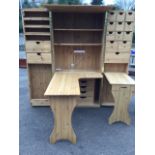 A large pine sewing cabinet with moulded cornice above fielded panelled cupboards revealing a fitted