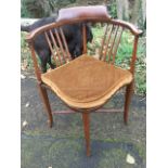 An Edwardian mahogany corner chair inlaid with boxwood stringing, the rounded back with slender