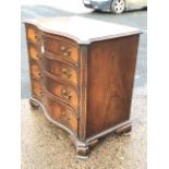 A Georgian style mahogany serpentine chest of drawers, the moulded top with fluted canted corners