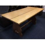 A rectangular oak refectory table, the three plank top on thick shaped mahogany trestle ends