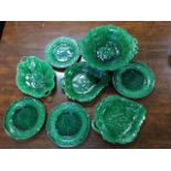 A collection of green glazed nineteenth century leaf moulded plates with large comport, a set of