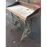 A cast iron Singer sewing machine table, the later oak top with upstand on pierced grill cast