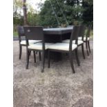 A contemporary rectangular dining table with eight chairs, the top with two draw leaves on column