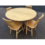 A set of four beech kitchen chairs with tapering spindlebacks raised on turned legs & stretchers;