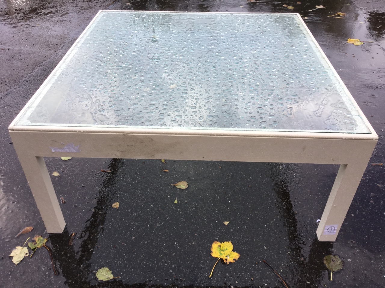 A large painted coffee table with plate glass top on square chamfered column legs. (37in x 35in x