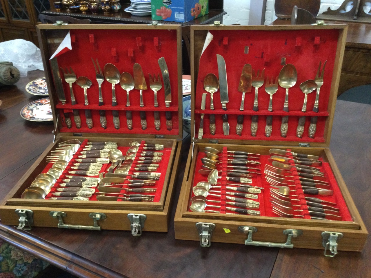 Two cased sets of eastern brass cutlery, the boxes each with trays, the pieces having embossed