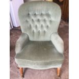 A button upholstered spoonback armchair with serpentine shaped loose cushion above sprung seat,