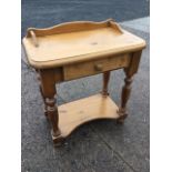 A small pine side table, the rectangular rounded top above a frieze drawer, raised on baluster
