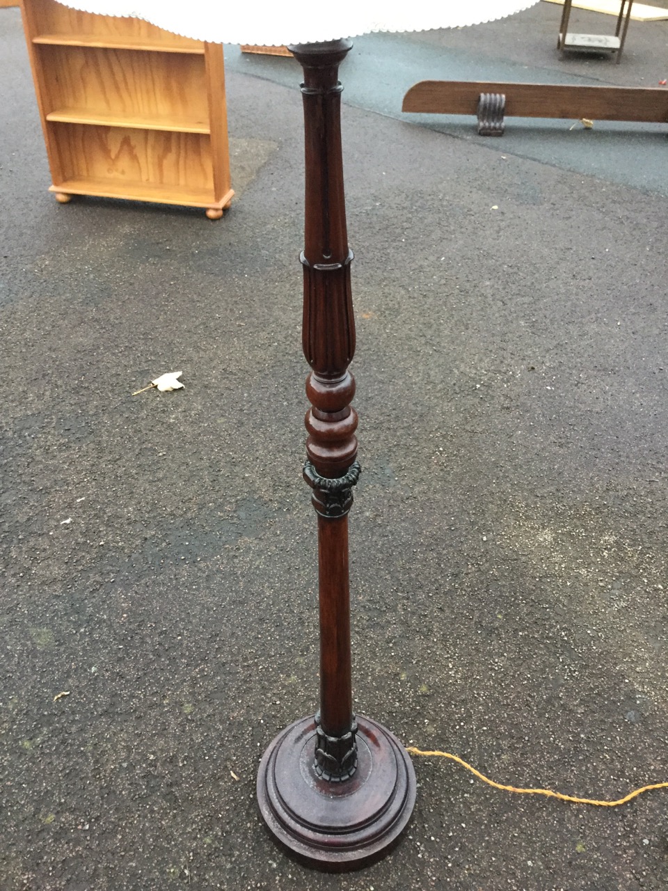 A carved mahogany standard lamp, with fluted turned leaf carved tapering column on circular