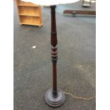 A carved mahogany standard lamp, with fluted turned leaf carved tapering column on circular