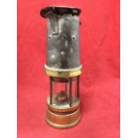 A Victorian brass miners lamp by Taylor of Wigan, with five columns framing tubular glass, having