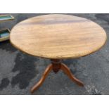 A circular nineteenth century pedestal table with oak top on hardwood turned column base with