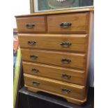 A reproduction pine chest of drawers, with two short and four long moulded drawers mounted with