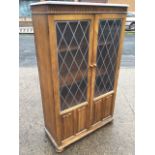 An oak leaded glass cabinet with adjustable internal shelves, the rectangular shaped top above a