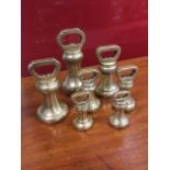 A set of seven Victorian brass weights of waisted baluster form, all with essay stamps and leaded