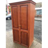 A modern cherrywood style wardrobe with moulded ogee cornice above fielded panelled doors
