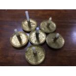 A set of six arts & crafts style brass candlesticks, the circular hammered dishes with tubular