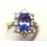 An 18ct gold sapphire & diamond cluster ring, the oval claw set sapphire of over two carats,
