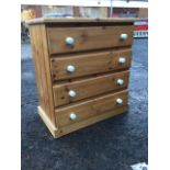 A Victorian style pine chest of four long drawers mounted with ceramic knobs, raised on plinth. (