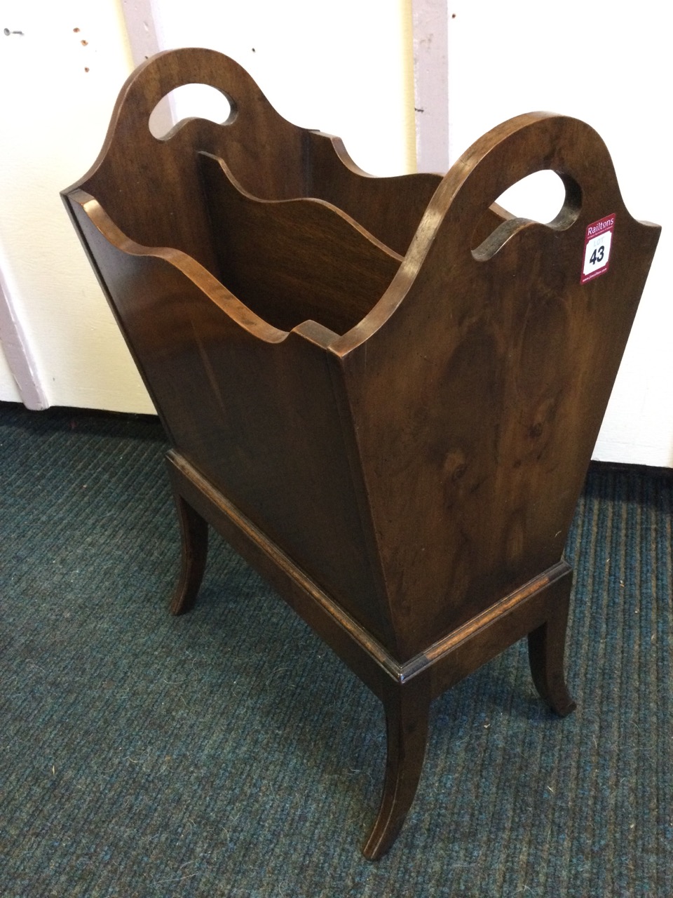 A yew magazine rack, the tapering box with two divisions on splayed legs, the sides with pierced