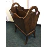 A yew magazine rack, the tapering box with two divisions on splayed legs, the sides with pierced