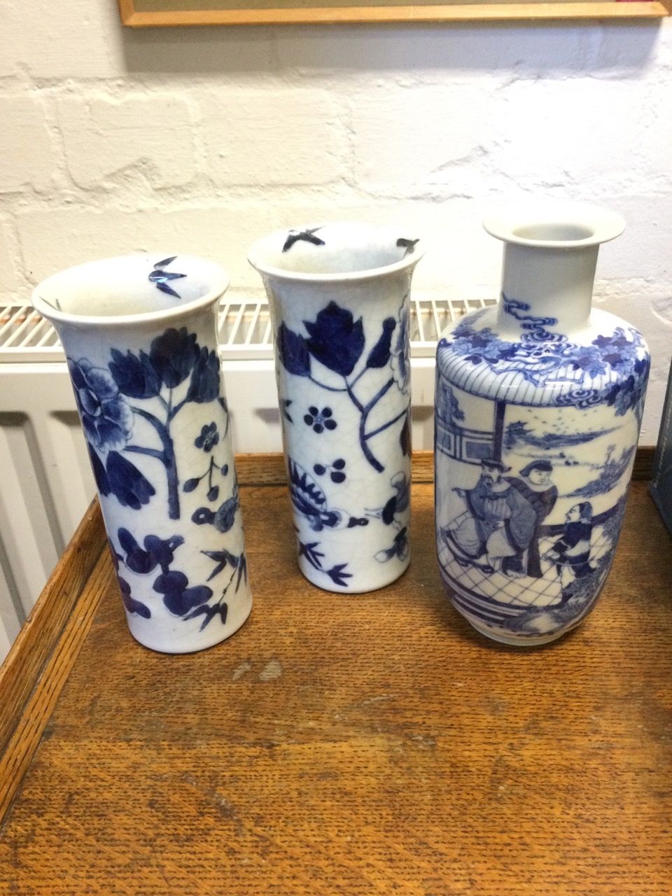 A pair of Japanese tubular vases with flared rims painted with birds, butterflies and prunus blossom