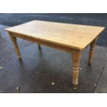 A pine kitchen table, the rectangular thick plank top on turned legs. (70.5in x 35.5in x 30.75in)