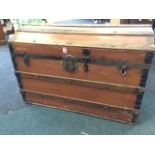 A domed top trunk with hardwood slats and iron mounts, having lined interior, with American lock and