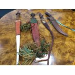 Three leather mounted knives, probably North African, with plaited thongs, tempered tapering steel