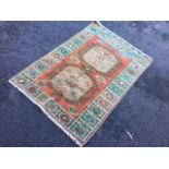 An oriental rug woven with two grey octagonal panels with hooked borders on an orange field,