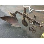 A Victorian cast iron harrow plough with cutting and guide wheels to shaft mounted with chain, the