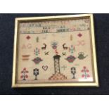 A gilt framed Victorian sampler dated 1863, with alphabet above panel of flowers, deer, vases,