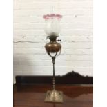 A Victorian brass oil lamp, the bun shaped copper reservoir in cage on square tapering turned column