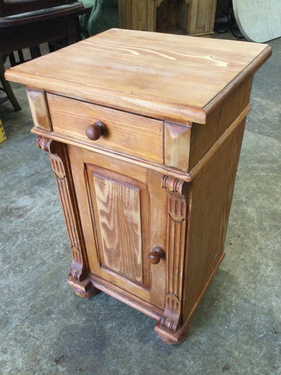 A small pine cupboard with moulded top above a drawer, having fielded panelled door below flanked by