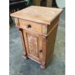 A small pine cupboard with moulded top above a drawer, having fielded panelled door below flanked by