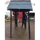 A garden shelter with pitched boarded roof and ends on rectangular frame, the ridge felted - never